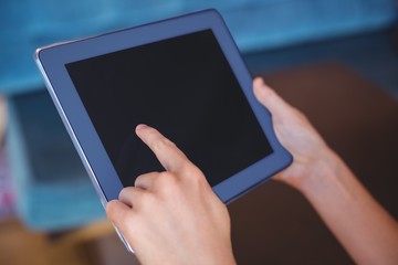 Pretty girl using a small tablet at table