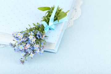 Forget-me-nots flowers on book, on blue background
