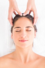 Naklejka premium Attractive woman receiving head massage at spa center