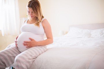 Obraz na płótnie Canvas Pregnant woman looking at her belly 