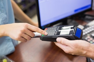 Woman at cash register paying with credit card