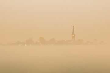 A typical dutch village in the foggy golden morning light.