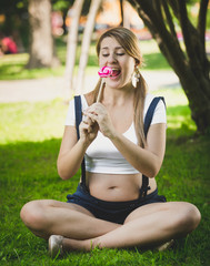 Funny shot of pregnant woman looking at lollipop