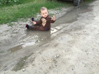 little boy in puddle