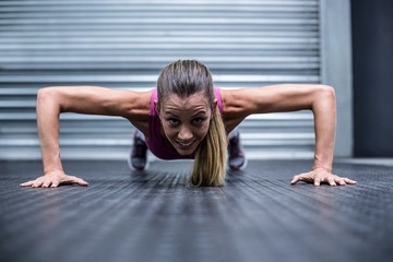 Fototapeta na wymiar Muscular woman doing push ups