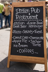 Black board with a menu restaurant in a typical traditional square in Florence , Italy