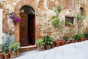 Fototapeta na wymiar The cobbled streets of the beautifully decorated walls with colorful flowers, Tuscany, Italy