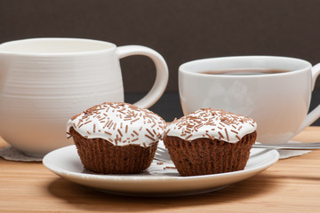Cupcakes With Cocoa White Cream And Sprinkles. Coffee And Milk