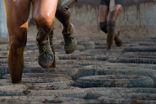 Mud race runners, tries to make it through the tire trap - Powered by Adobe