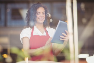 Smiling waitress using a digital tablet