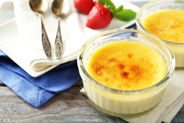 Creme brulee dessert  on napkin, on color wooden background