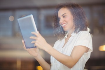 Fototapeta premium Smiling woman using a digital tablet
