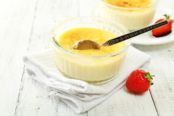 Creme brulee dessert  on napkin, on color wooden background