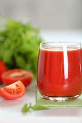 Tomato juice and fresh tomatoes on wooden table close-up