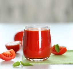 Tomato juice and fresh tomatoes on wooden table close-up