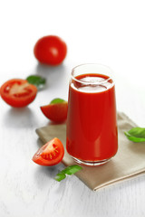 Tomato juice and fresh tomatoes on wooden table close-up