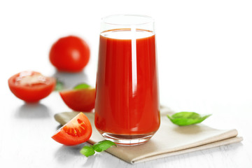 Tomato juice and fresh tomatoes on wooden table close-up