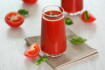 Tomato juice and fresh tomatoes on wooden table close-up
