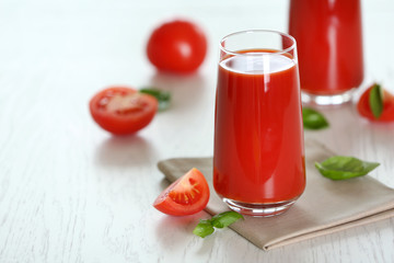 Tomato juice and fresh tomatoes on wooden table close-up
