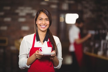 Smiling waitress holding a cup of coffee
