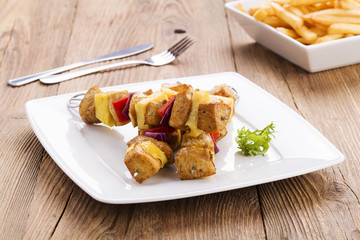 Grilled chicken skewers with pineapple, peppers and onions serve