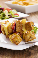 Grilled chicken skewers with pineapple, peppers and onions serve