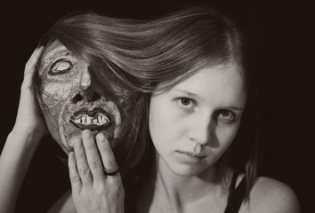 Portrait of a young woman with spooky theatrical mask