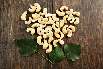 Cashew arranged in heart shape on wooden background