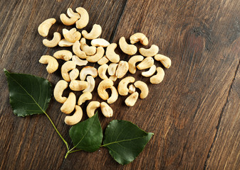 Cashew arranged in heart shape on wooden background