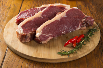 raw meat : fresh beef fillet with garlic and green stuff on wood