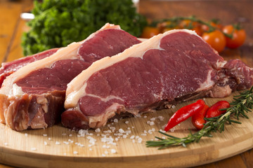 raw meat : fresh beef fillet with garlic and green stuff on wood