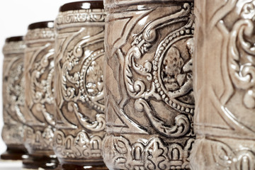 Close-up of decorated pottery tankards placed in row