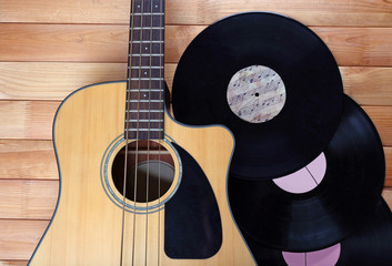 Fototapeta premium Guitar and vinyl records on wooden table close up