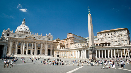 St. Peter's Square, Vatican City. Wide angle view with the Basilica and Popes palace creating a background to the visiting tourists and pilgrims. - obrazy, fototapety, plakaty