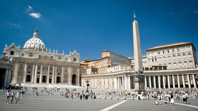 St. Peter's Square, Vatican City. Wide angle view with the Basilica and Popes palace creating a background to the visiting tourists and pilgrims.