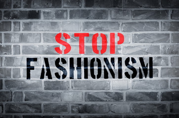 Stop Fashionism stencil print on the grunge brick wall