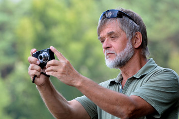 Mann auf Motivsuche mit Kompaktkamera