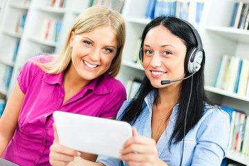 Students learning in library, using digital tablet