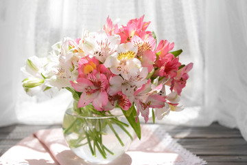 Beautiful bright bouquet in vase on fabric background