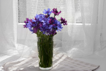 Beautiful bright bouquet in vase on fabric background
