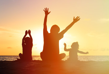 Fototapeta premium Silhouette of happy father and kids at sunset