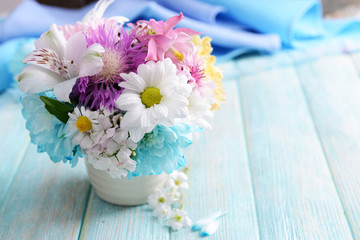 Beautiful bright bouquet in vase on wooden background