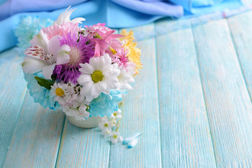 Beautiful bright bouquet in vase on wooden background