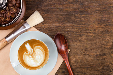 A cup of coffee on the brown wooden background