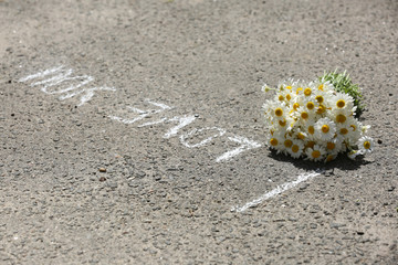 Beautiful bouquet of daisies on asphalt outdoors