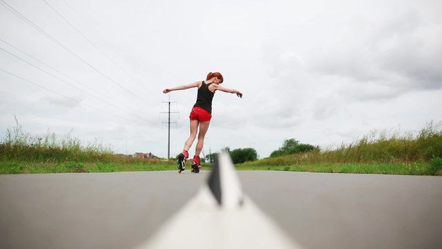 Young roller skater skating between cups on the road