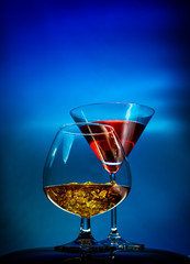 Two glasses with alcohol, martini and cognac