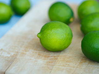 Whole limes closeup on wooden cutting board