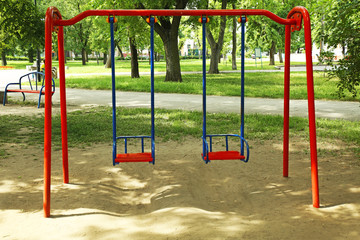 Empty chain swings on playground in yard