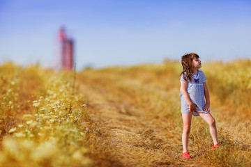 girl in a striped dress walking on the meadow
